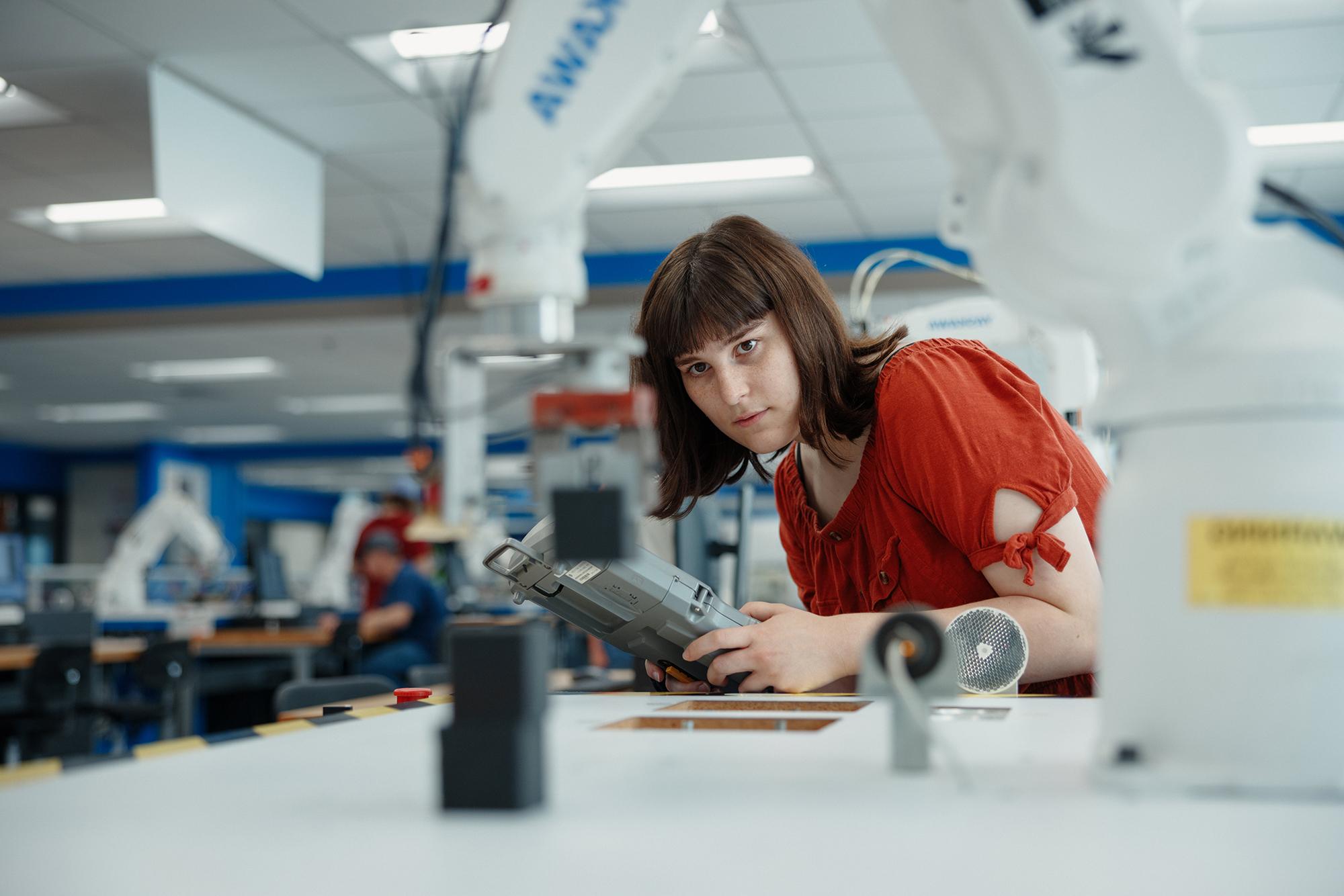 Student working with robot arm.